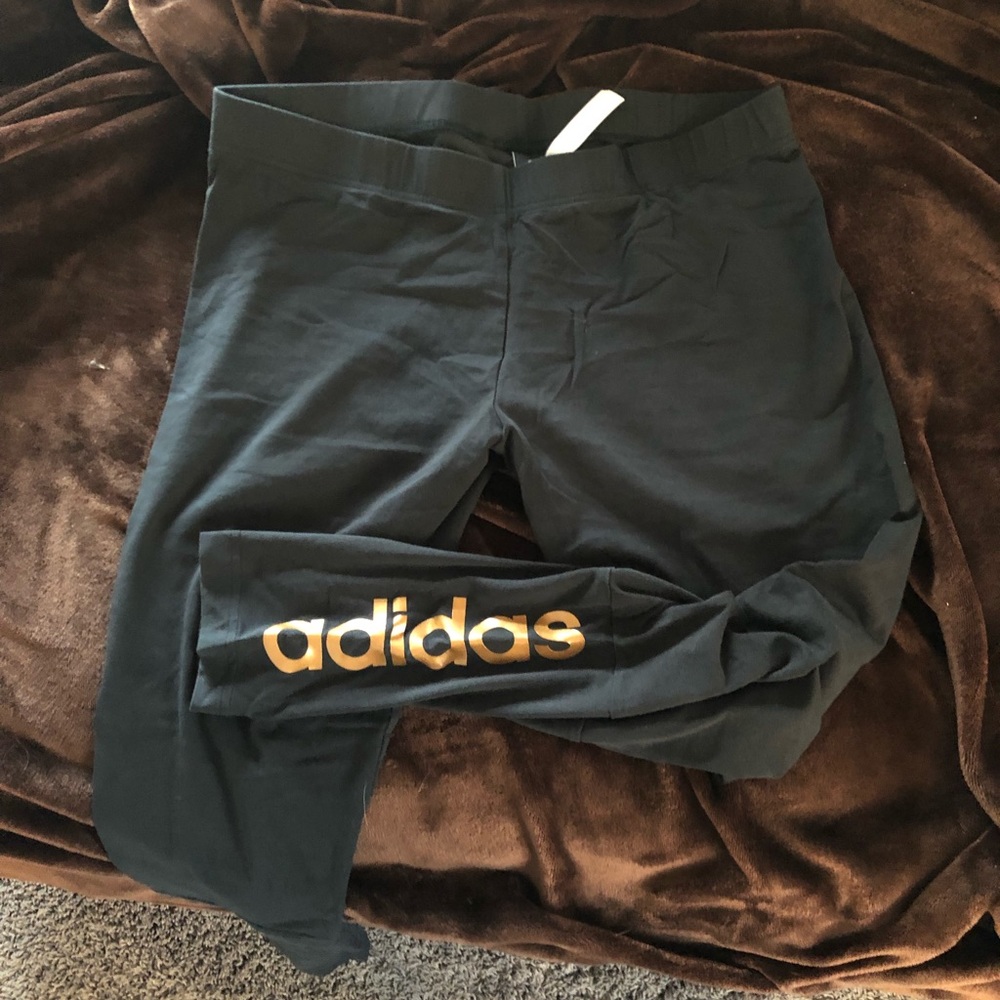 Black Adidas legging with gold “Adidas” on bottom